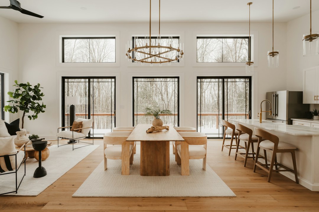 A close-up of a firm, professional handshake between a real estate agent and a client inside a bright, modern living room, symbolizing a successful home sale agreement.