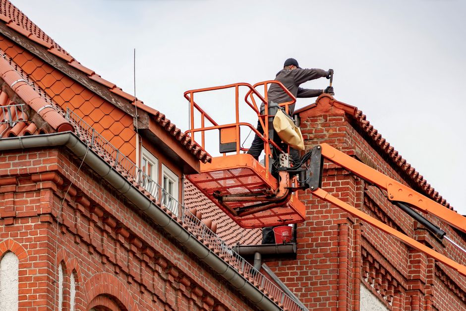 A professional contractor in protective gear carefully applies spray foam insulation to the interior of a home's attic, showcasing a key method for improving energy efficiency.